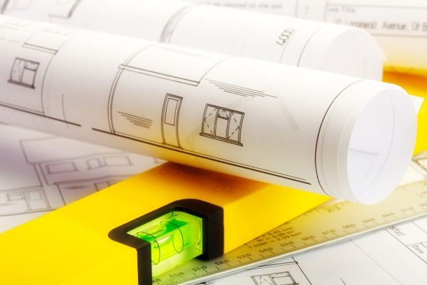 Close up image of plans for a house with ruler and spirit level