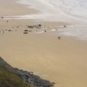 Distant walkers on a big, sandy beach