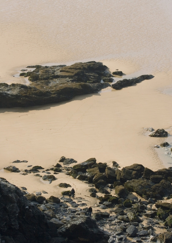 A large, empty, sandy beach with big rocks