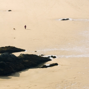 Solitary walker on a big, sandy beach