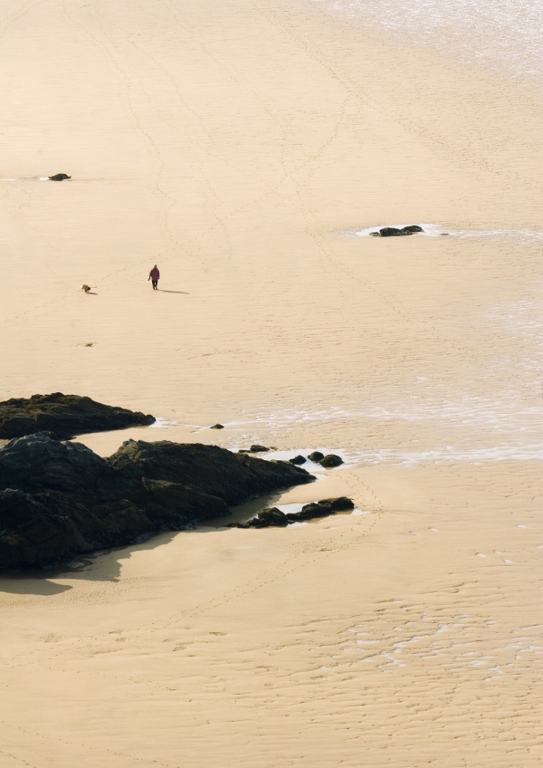 Solitary walker on a big, sandy beach