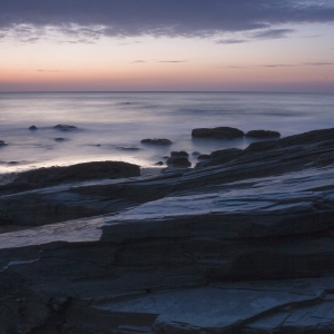 A cloudy sunset on a rocky shore