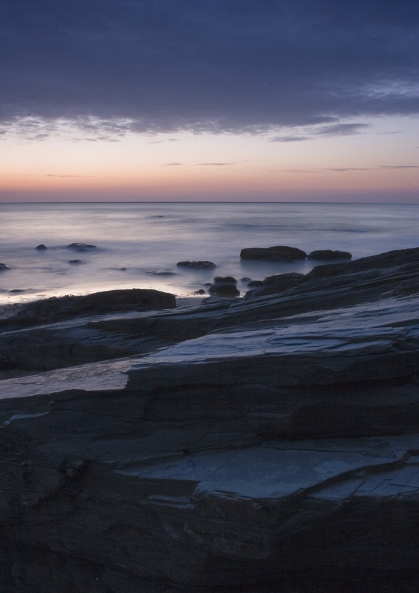 A cloudy sunset on a rocky shore