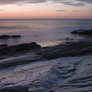 An orange sunset on a rocky beach in Cornwall