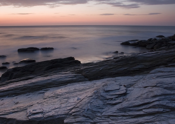 An orange sunset on a rocky beach in Cornwall