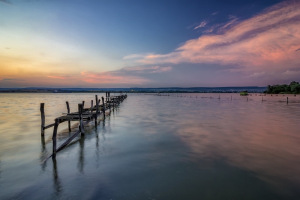 Long exposure landscape with old broken pier with reflection