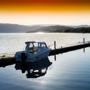 A small boat moored at a pier in Norwegian fiords