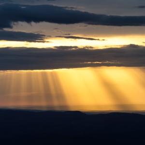 Cloudy sunset with silhouetted hills in the background