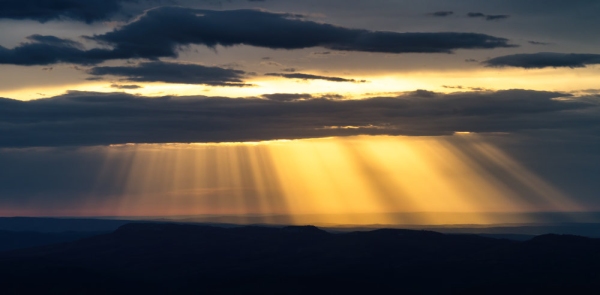 Cloudy sunset with silhouetted hills in the background