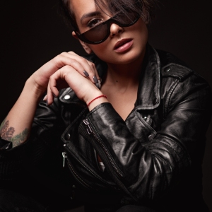 Beauty sexy woman in a leather jacket. Portrait on a dark background