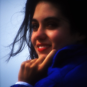 A smiling pretty brunette girl or young woman looking into camera. Soft focus