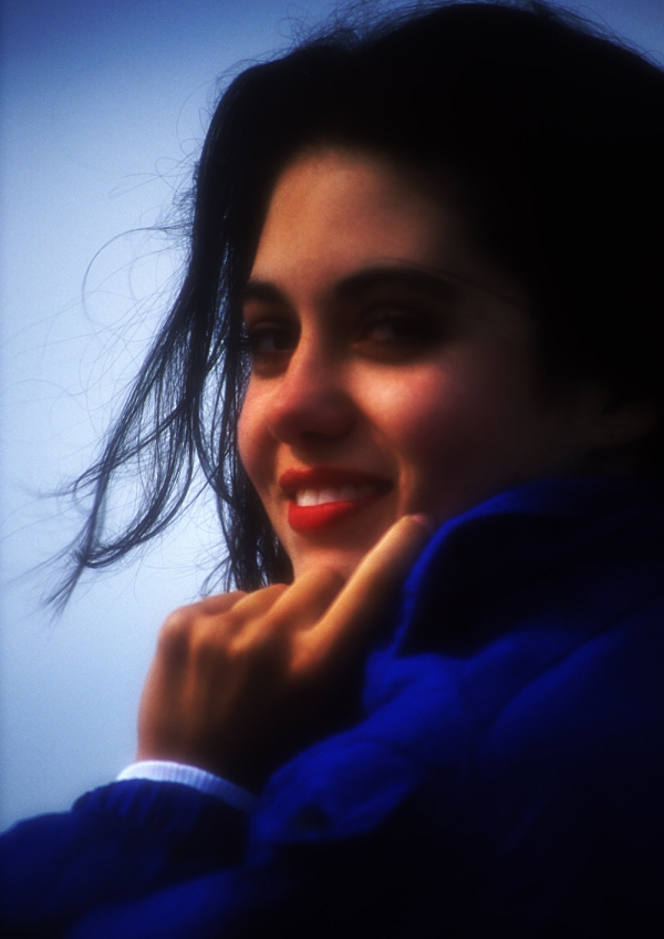 A smiling pretty brunette girl or young woman looking into camera. Soft focus