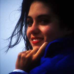 A smiling pretty brunette girl or young woman looking into camera. Soft focus