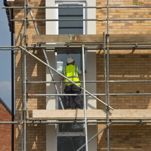 builders working on a new housing development on scaffolding