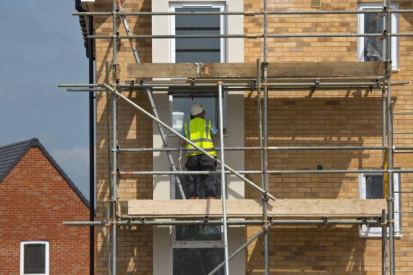 builders working on a new housing development on scaffolding