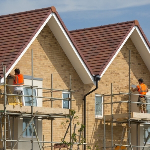 builders working on a new housing development on scaffolding