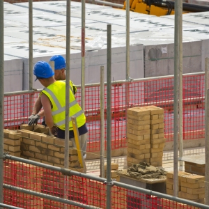 Two bricklayers laying bricks on a new housing development