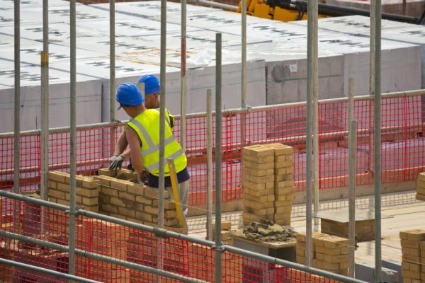 Two bricklayers laying bricks on a new housing development