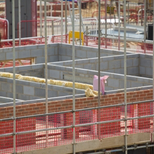 A building site on a large new greenfield housing development with breeze blocks, half built walls, bricks and scaffolding