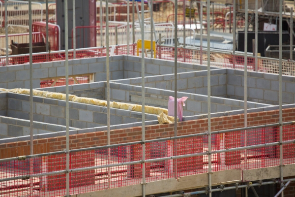 A building site on a large new greenfield housing development with breeze blocks, half built walls, bricks and scaffolding