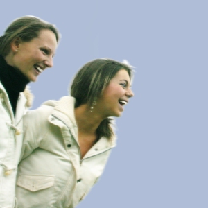 Two girls having fun on a sunny day against a blue sky