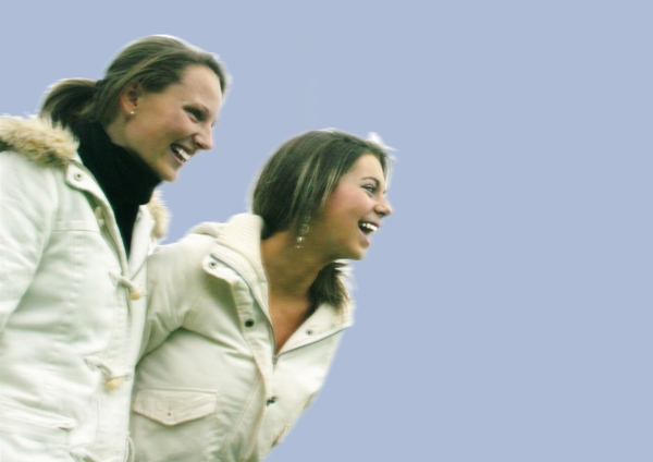 Two girls having fun on a sunny day against a blue sky