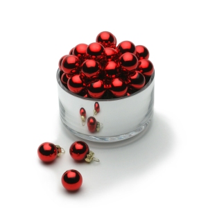 Shiny red Christmas baubles in a bright silver container