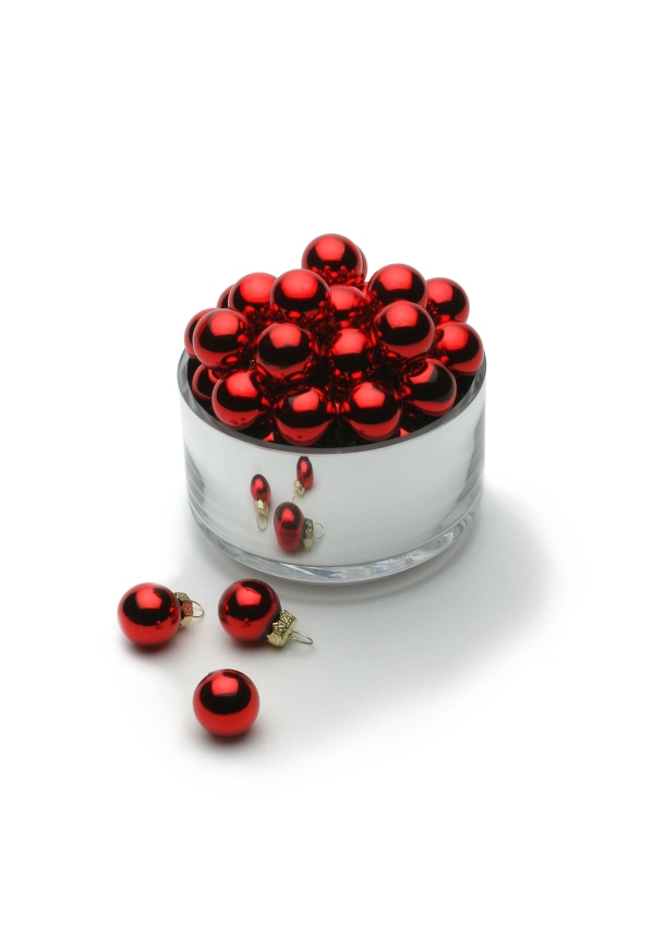 Shiny red Christmas baubles in a bright silver container