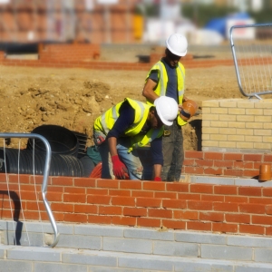 Two Construction workers laying the drains in a new house