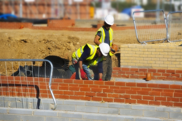 Two Construction workers laying the drains in a new house