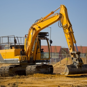 A digger or earth mover with caterpillar tracks on a building site