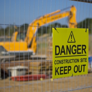 Warning sign on a construction site fence