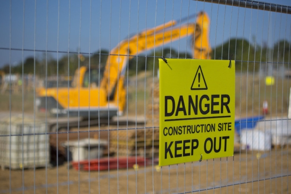 Warning sign on a construction site fence