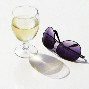 Glass of white wine and rayban aviator sunglasses