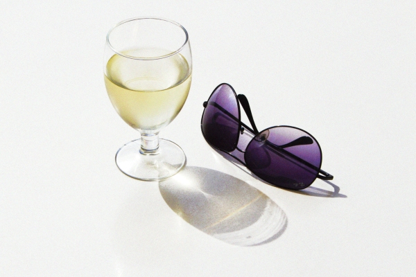 Glass of white wine and rayban aviator sunglasses