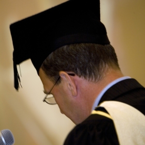 University official in full regalia on graduation day dispensing degree qualifications