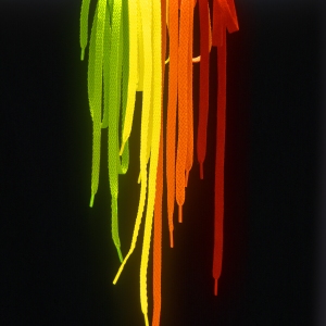 A selection of brightly coloured shoelaces on a chrome bar against a black background