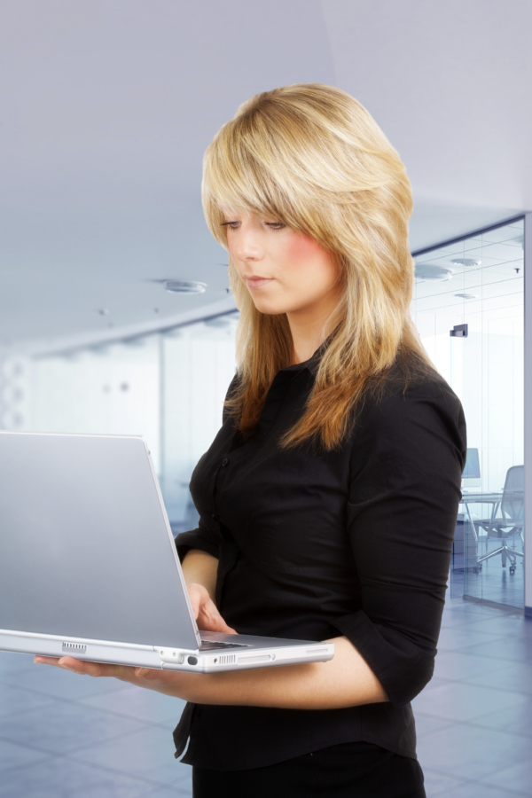 A pretty young girl looking at a laptop computer