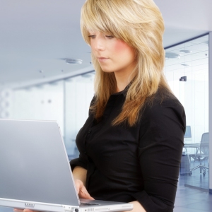 A pretty young girl looking at a laptop computer