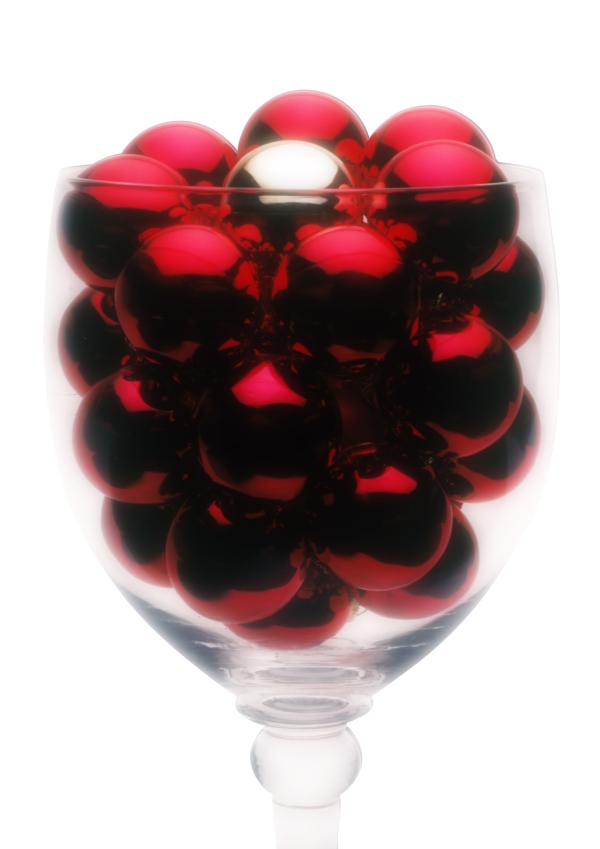 Red Christmas baubles or balls with one silver one in a large glass