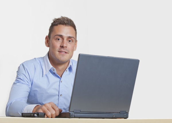 Handsome young man at work on a laptop computer