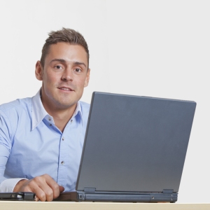 Handsome young man at work on a laptop computer