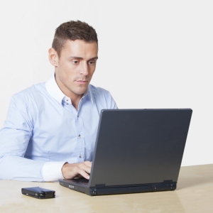 handsome young man working on a laptop computer