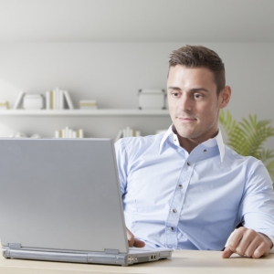 Handsome young man at work on a laptop computer