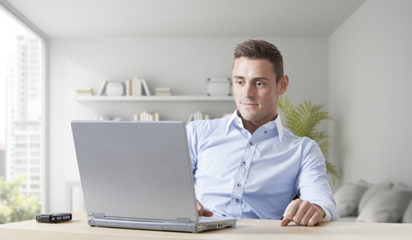 Handsome young man at work on a laptop computer