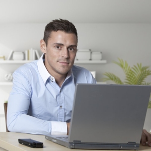 Handsome young man at work on a laptop computer