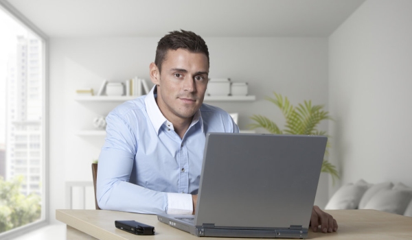 Handsome young man at work on a laptop computer