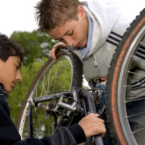 Two young boys fixing a bicycle