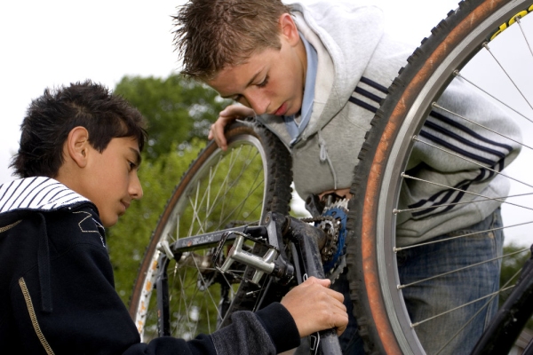 Two young boys fixing a bicycle