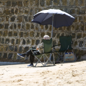 Man relaxing on a beach under a parasol